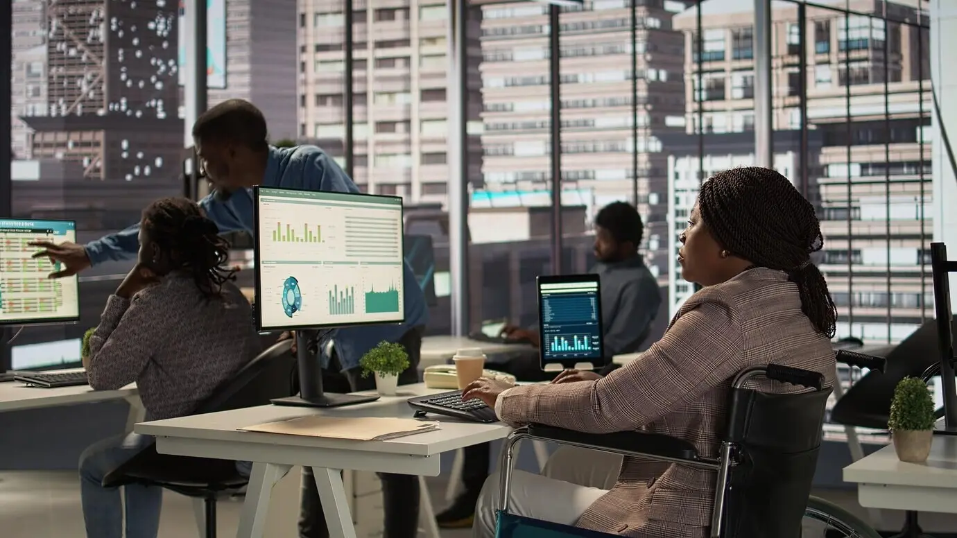 Gerente, persona negra que usa silla de ruedas, revisa los datos financieros para los informes mensuales.